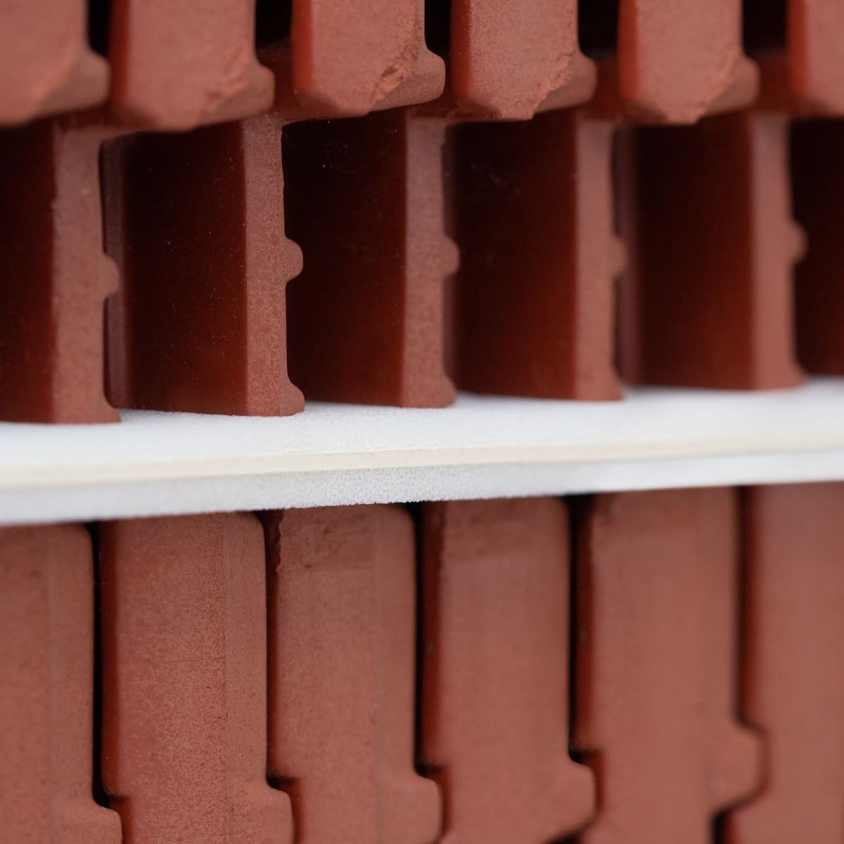 Industrial packaging roof tiles on pallet with intermediate layers of solid board laminated with foam - Detail view edge